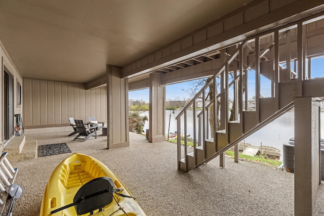 view of patio featuring central air condition unit and a water view