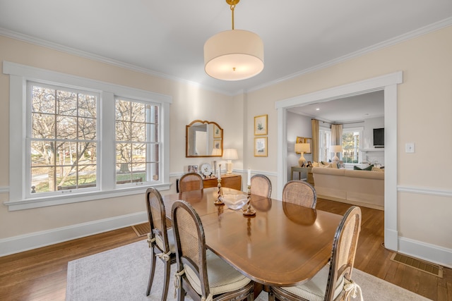 dining space with ornamental molding and hardwood / wood-style flooring