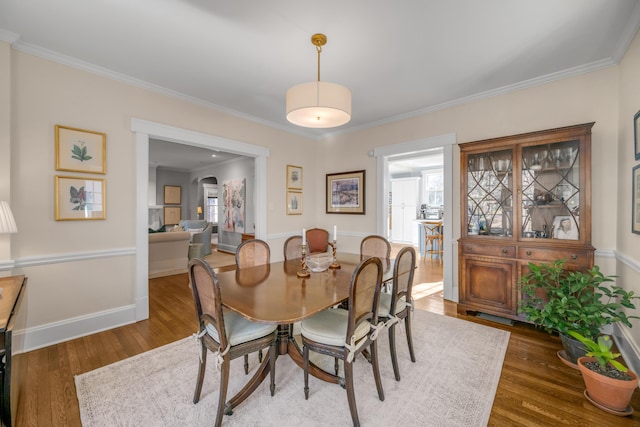 dining space with dark wood-type flooring and crown molding