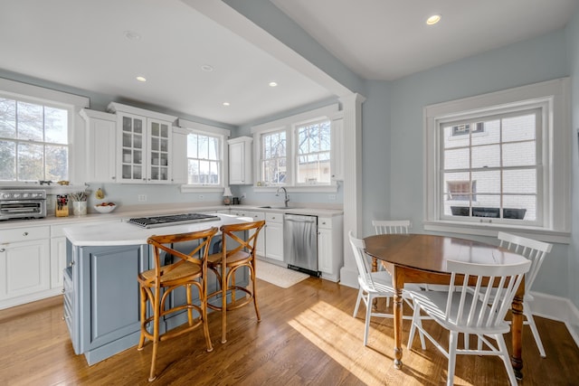 kitchen with white cabinets, sink, a kitchen island, a kitchen bar, and stainless steel appliances