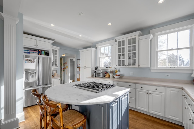 kitchen featuring white cabinetry, a center island, stainless steel appliances, and light hardwood / wood-style floors