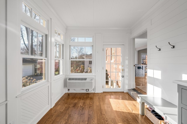 unfurnished sunroom featuring a wall unit AC and plenty of natural light