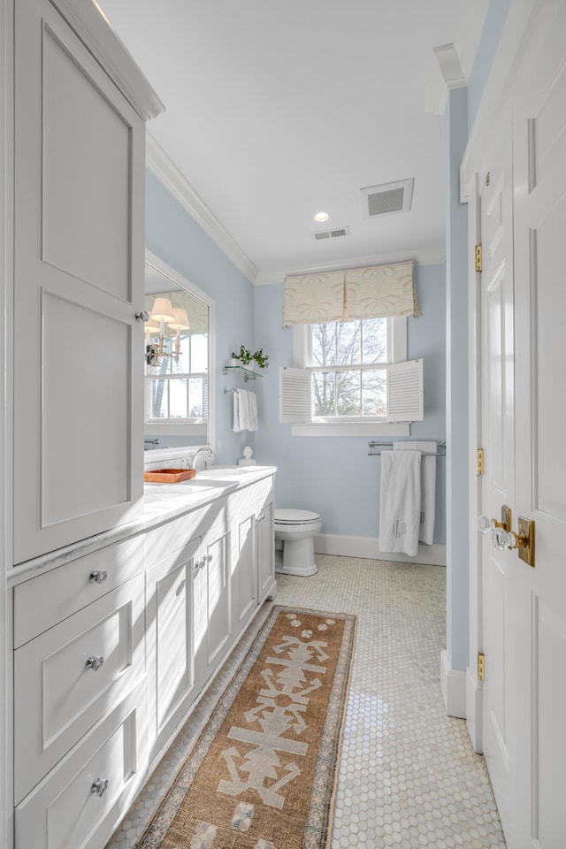 bathroom featuring tile patterned floors, vanity, toilet, and crown molding