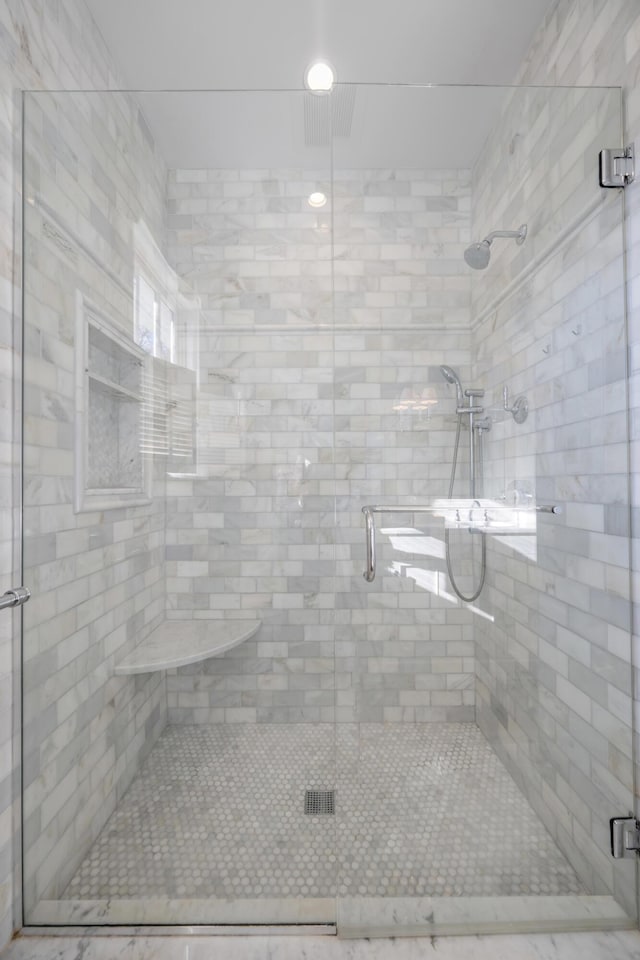 bathroom featuring a shower with shower door