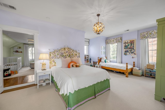 carpeted bedroom with lofted ceiling and a notable chandelier