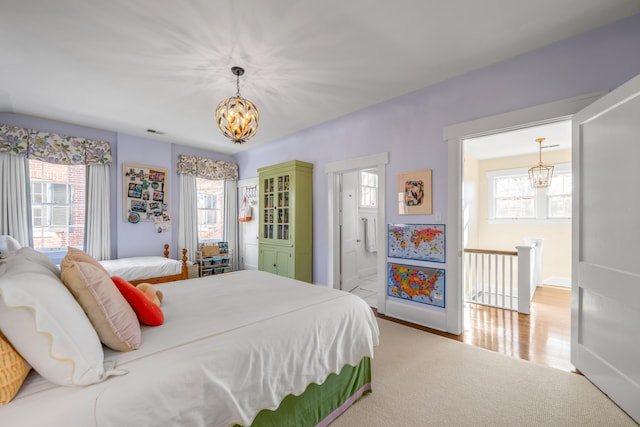 bedroom with connected bathroom and a chandelier