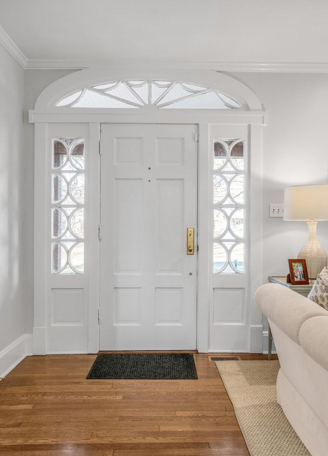 entryway with hardwood / wood-style flooring and ornamental molding