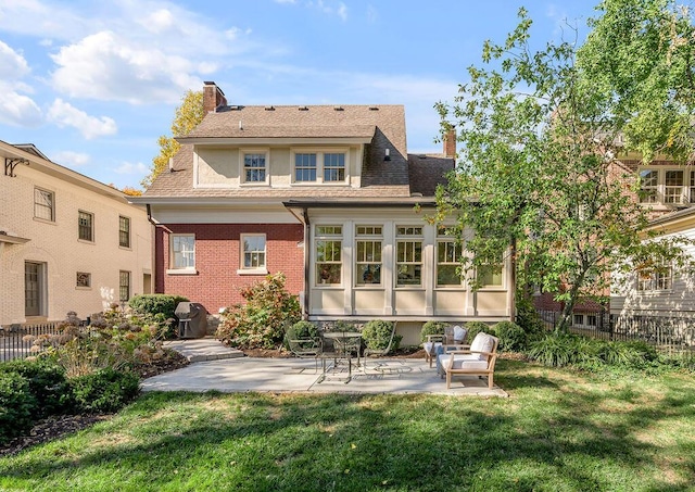 rear view of house featuring a lawn and a patio area