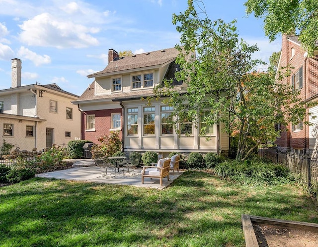 rear view of property with a lawn and a patio