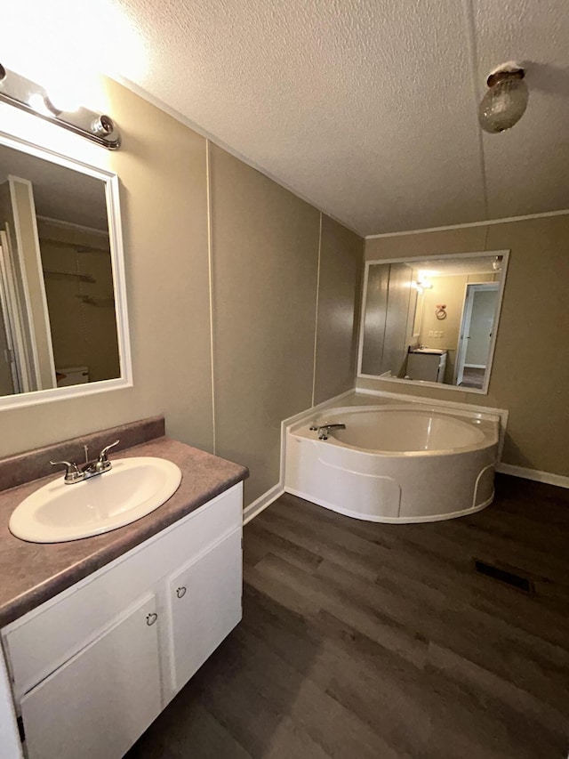 bathroom with hardwood / wood-style floors, vanity, and a textured ceiling