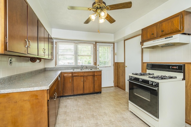 kitchen featuring ceiling fan, decorative backsplash, sink, and white range with gas cooktop