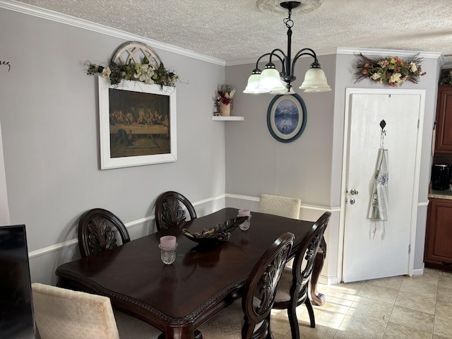 dining space featuring a textured ceiling, light tile patterned floors, ornamental molding, and a notable chandelier