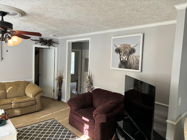 living room featuring ceiling fan, light colored carpet, ornamental molding, and a textured ceiling