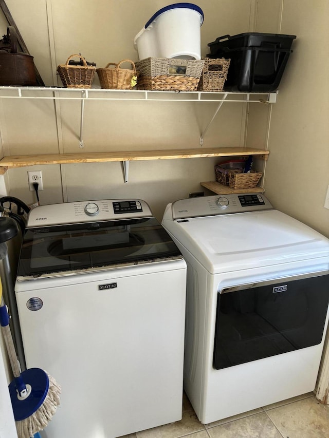 laundry area with washer and dryer and light tile patterned flooring