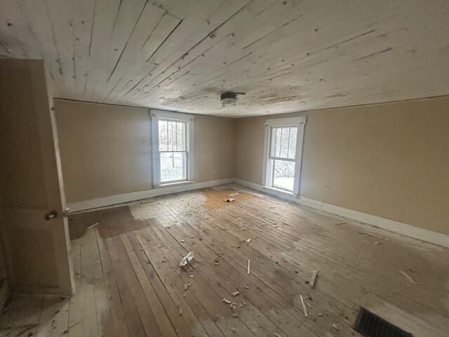 spare room with plenty of natural light, wooden ceiling, and light hardwood / wood-style flooring