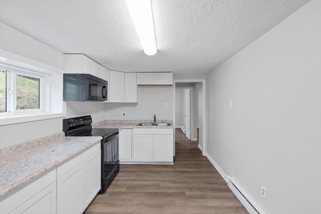 kitchen with sink, light hardwood / wood-style flooring, a textured ceiling, white cabinets, and black appliances