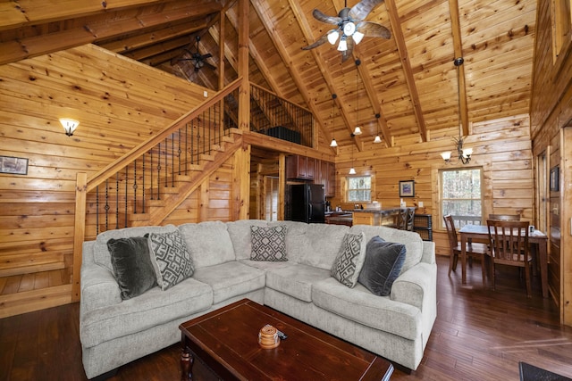 living room with wooden ceiling, dark wood-type flooring, high vaulted ceiling, ceiling fan with notable chandelier, and wooden walls