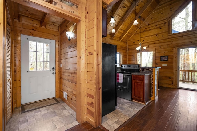 kitchen featuring wood walls, wooden ceiling, black appliances, beamed ceiling, and dark hardwood / wood-style flooring