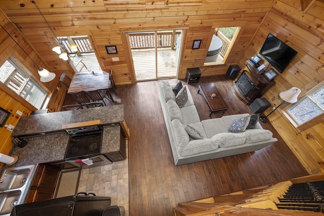 living room featuring wood-type flooring, wood ceiling, lofted ceiling, and wood walls