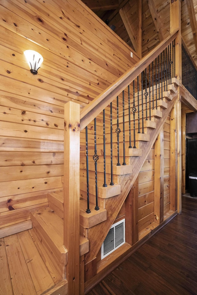 stairs with wood walls, hardwood / wood-style floors, and wood ceiling