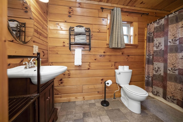 bathroom featuring a shower with curtain, wood walls, toilet, vanity, and wood ceiling