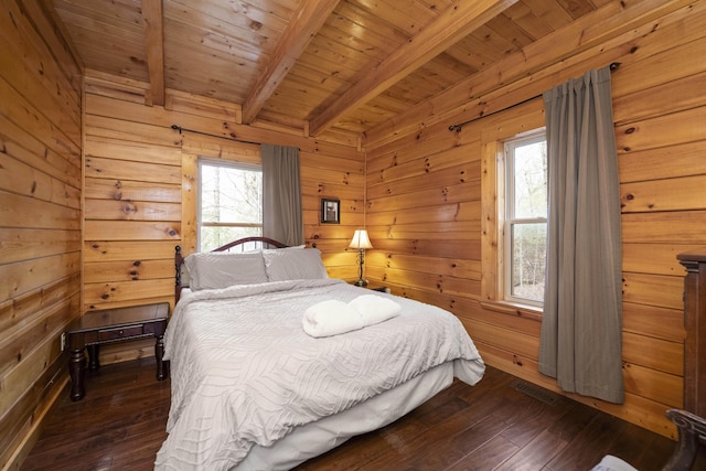 bedroom featuring beamed ceiling, wooden walls, wooden ceiling, and dark wood-type flooring