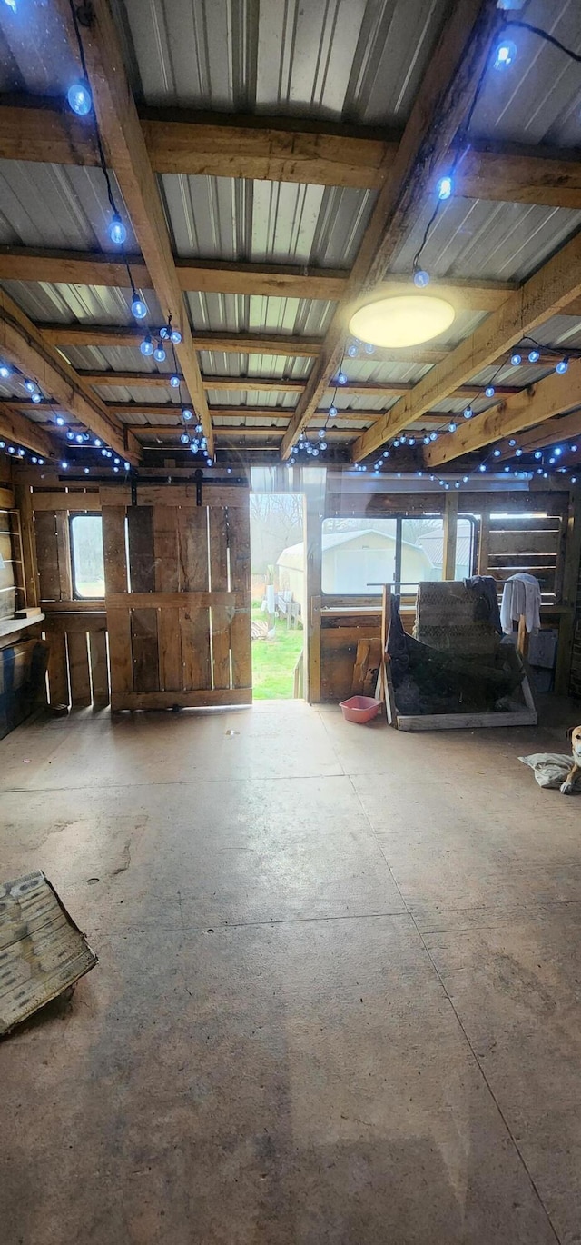 misc room with concrete flooring and beamed ceiling