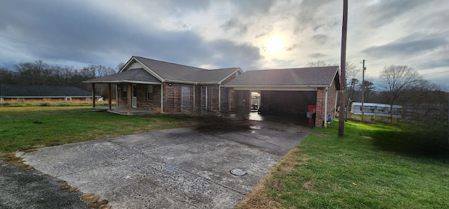 single story home featuring covered porch, a garage, and a front yard