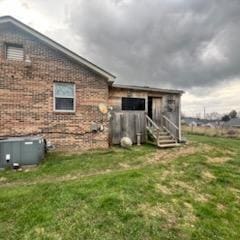 view of property exterior with brick siding and a lawn