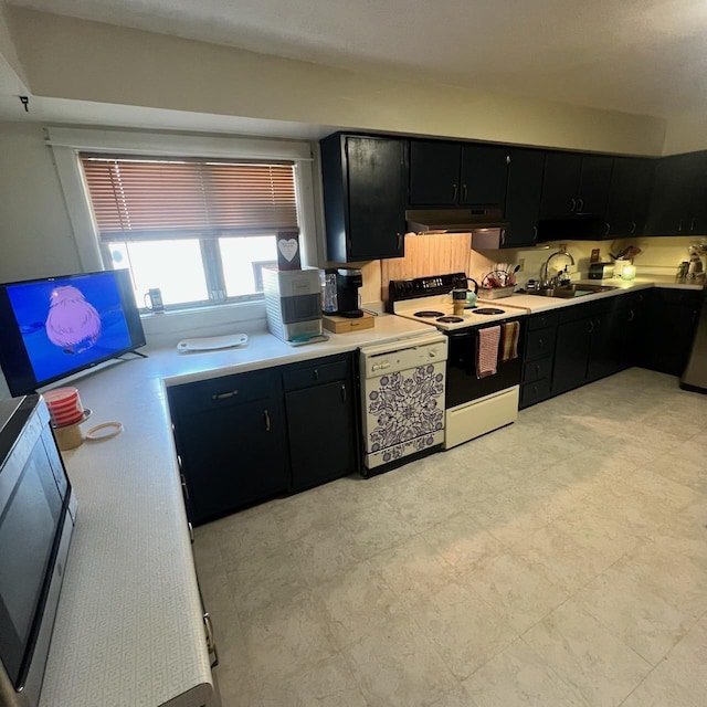 kitchen featuring a sink, dark cabinets, under cabinet range hood, and electric stove