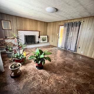 unfurnished living room featuring a fireplace and wooden walls