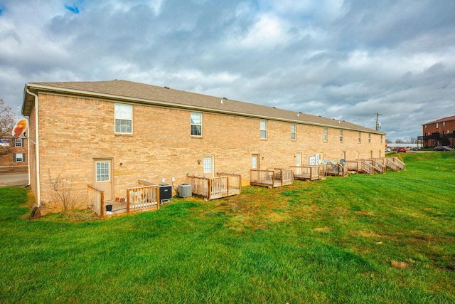 rear view of property with a lawn and central AC