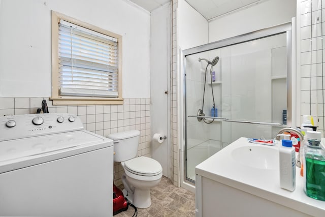 bathroom featuring washer / dryer, vanity, toilet, and tile walls