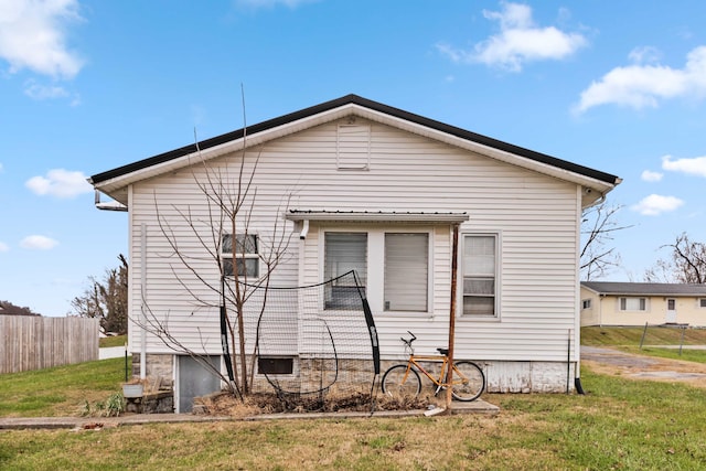 view of side of home with a yard