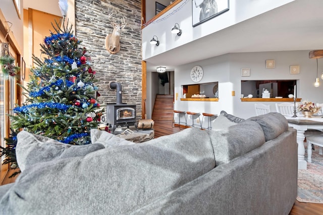 living room featuring hardwood / wood-style flooring, a wood stove, and a high ceiling