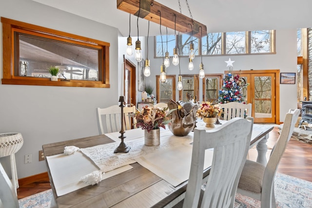 dining area with french doors, hardwood / wood-style flooring, and a high ceiling