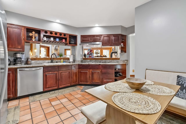 kitchen with stainless steel dishwasher, light tile patterned floors, and sink