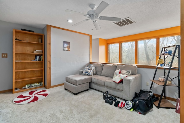 living room featuring carpet flooring, a textured ceiling, and ceiling fan