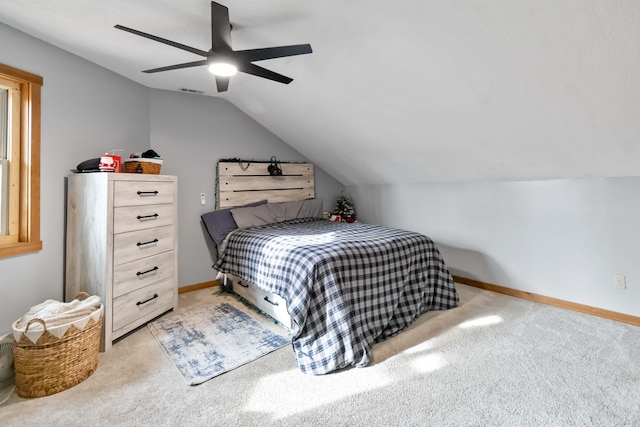 bedroom with ceiling fan, light colored carpet, and vaulted ceiling