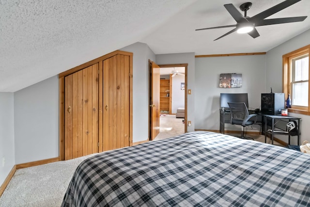 carpeted bedroom featuring ceiling fan, a textured ceiling, and vaulted ceiling