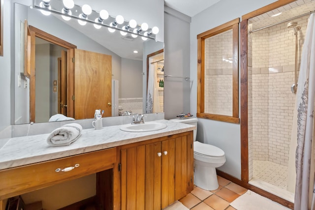 bathroom featuring tile patterned floors, vanity, toilet, and tiled shower