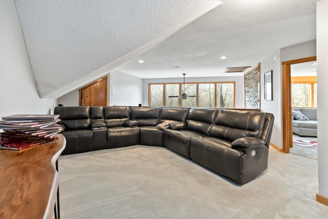 living room with ceiling fan, light colored carpet, plenty of natural light, and a textured ceiling