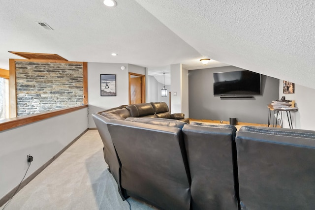 carpeted home theater room featuring a textured ceiling