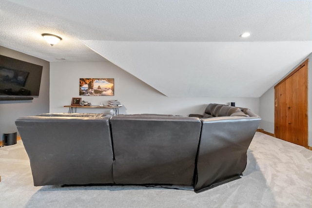 living room featuring lofted ceiling, a textured ceiling, and carpet floors