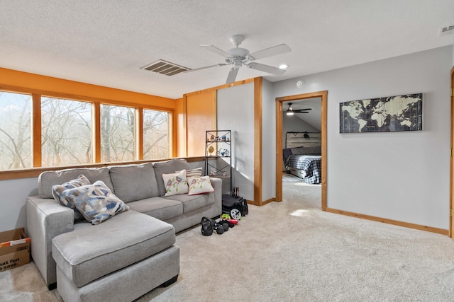 carpeted living room with a textured ceiling and ceiling fan