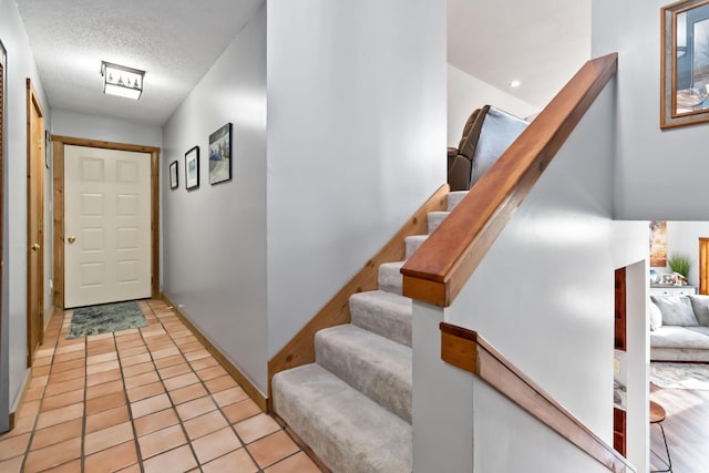 interior space with light tile patterned floors and a textured ceiling