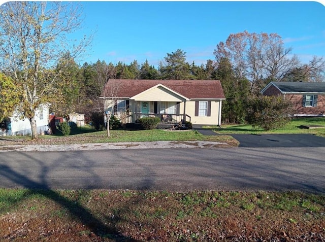 view of front of house with covered porch and a front lawn