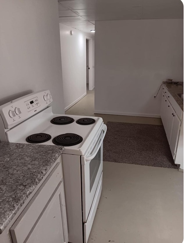 kitchen featuring white electric range oven and white cabinetry