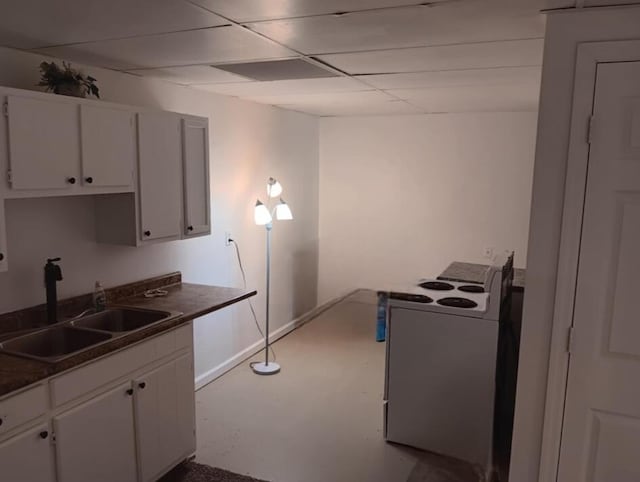 kitchen featuring white cabinetry, dark countertops, a sink, and electric range oven