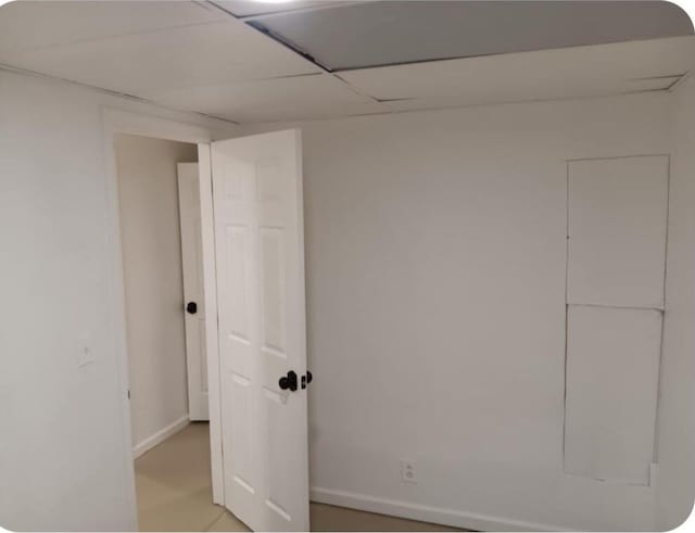 basement featuring baseboards and a paneled ceiling
